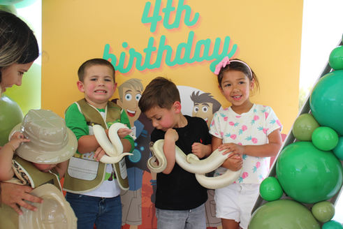 Children holding ball pythons at a birthday party