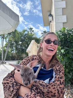 Guest holding a small kangaroo during an animal encounter